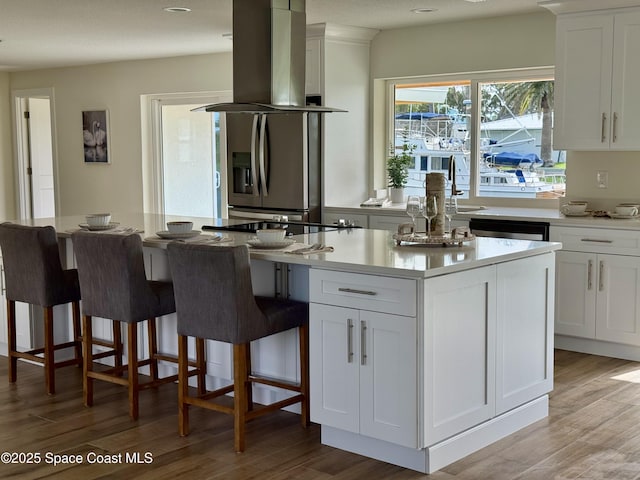 57 Riverview Ln, Cocoa Beach, FL 32931 - kitchen featuring island exhaust hood, white cabinetry, light wood-style floors, and a sink