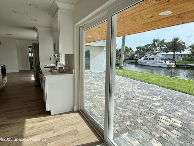 57 Riverview Ln, Cocoa Beach, FL 32931 - doorway to outside with a water view, a sink, and baseboards
