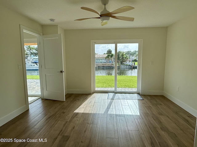 57 Riverview Ln, Cocoa Beach, FL 32931 - empty room with a water view, ceiling fan, plenty of natural light, and wood finished floors