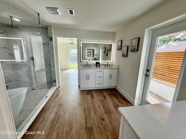 57 Riverview Ln, Cocoa Beach, FL 32931 - full bath with a marble finish shower, double vanity, healthy amount of natural light, and a ceiling fan