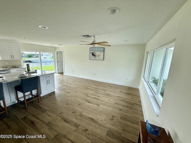 57 Riverview Ln, Cocoa Beach, FL 32931 - living room with wood finished floors, a textured ceiling, a ceiling fan, and baseboards