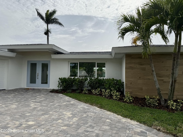 57 Riverview Ln, Cocoa Beach, FL 32931 - doorway to property with french doors and stucco siding