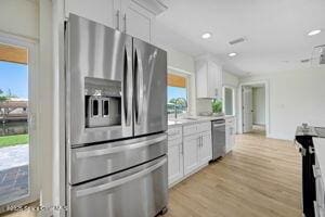 57 Riverview Ln, Cocoa Beach, FL 32931 - kitchen featuring appliances with stainless steel finishes, white cabinets, plenty of natural light, light wood-style floors, and recessed lighting