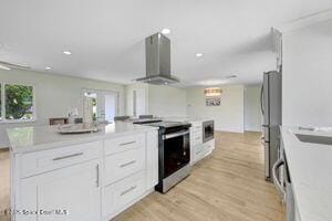 57 Riverview Ln, Cocoa Beach, FL 32931 - kitchen featuring appliances with stainless steel finishes, wall chimney exhaust hood, white cabinets, light countertops, and recessed lighting