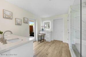 57 Riverview Ln, Cocoa Beach, FL 32931 - full bathroom featuring a marble finish shower, vanity, and wood finished floors