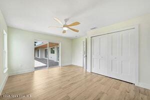 57 Riverview Ln, Cocoa Beach, FL 32931 - unfurnished bedroom with wood finished floors, a closet, and ceiling fan