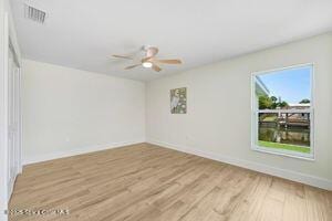 57 Riverview Ln, Cocoa Beach, FL 32931 - spare room with wood finished floors and ceiling fan