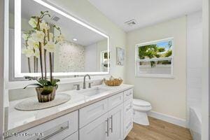 57 Riverview Ln, Cocoa Beach, FL 32931 - full bathroom featuring vanity, wood finished floors, a tub, and a shower