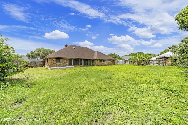 2180 Figtree Dr Unit 0, Titusville, FL 32780 - back of house with a fenced backyard, brick siding, and a chimney
