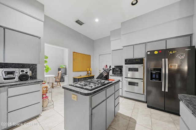 2180 Figtree Dr Unit 0, Titusville, FL 32780 - kitchen with stainless steel appliances, gray cabinetry, dark countertops, a kitchen island, and light tile patterned floors