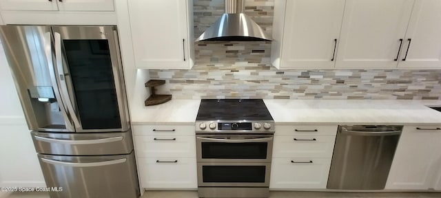 290 Paradise Blvd # 84, Indialantic, FL 32903 - kitchen with stainless steel appliances, backsplash, light countertops, white cabinets, and wall chimney range hood
