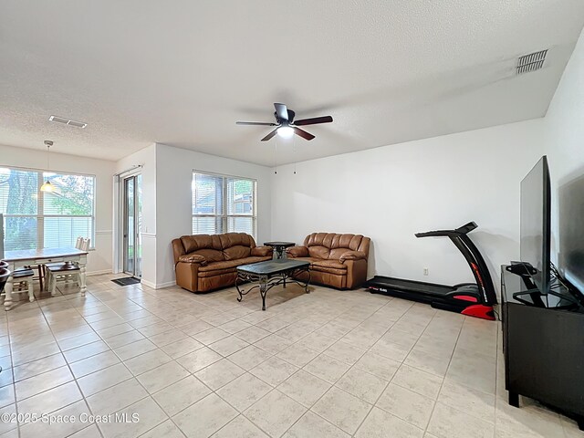 9525 Southern Garden Cir, Altamonte Springs, FL 32714 - living room featuring a textured ceiling, light tile patterned floors, ceiling fan, healthy amount of natural light, and baseboards