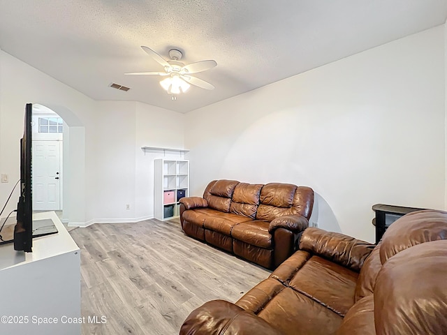 9525 Southern Garden Cir, Altamonte Springs, FL 32714 - living room featuring light wood finished floors, ceiling fan, arched walkways, baseboards, and a textured ceiling