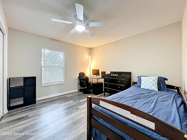 9525 Southern Garden Cir, Altamonte Springs, FL 32714 - bedroom featuring wood finished floors, a textured ceiling, a ceiling fan, and baseboards