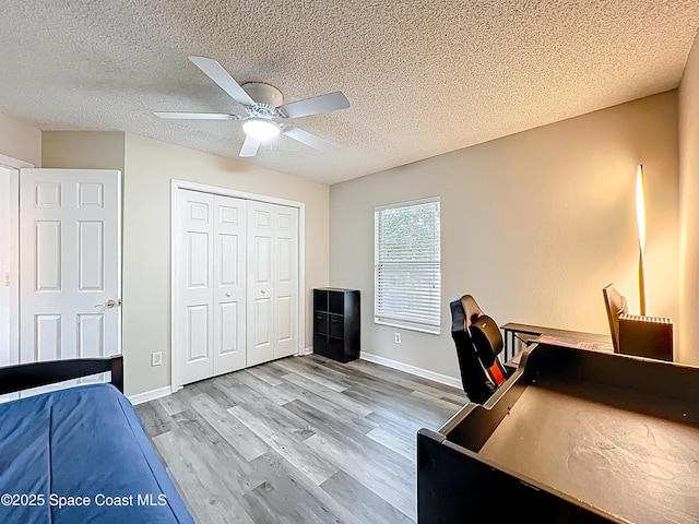 9525 Southern Garden Cir, Altamonte Springs, FL 32714 - bedroom featuring light wood-type flooring, a textured ceiling, a ceiling fan, baseboards, and a closet