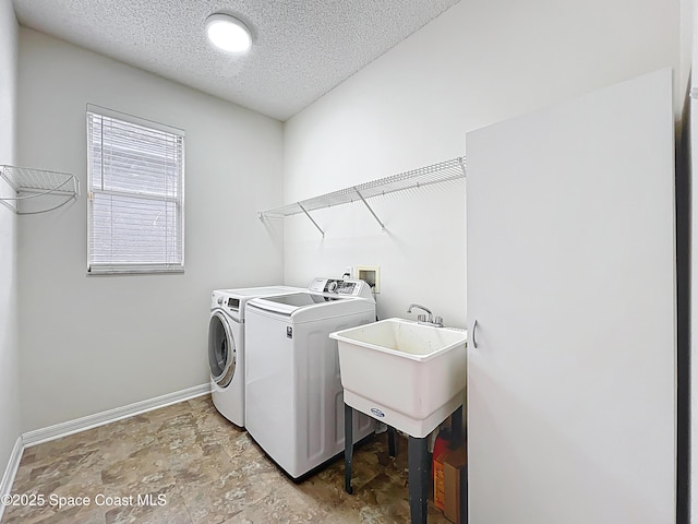 9525 Southern Garden Cir, Altamonte Springs, FL 32714 - laundry room featuring independent washer and dryer, a textured ceiling, baseboards, and light stone finish floors