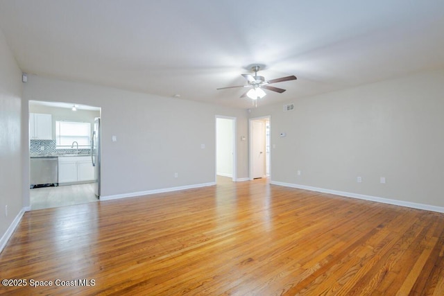 1108 Abington St, Cocoa, FL 32922 - empty room with ceiling fan, light wood finished floors, baseboards, and a sink