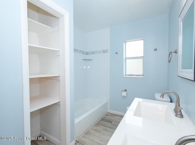 1108 Abington St, Cocoa, FL 32922 - bathroom with wood finished floors, washtub / shower combination, baseboards, and double vanity