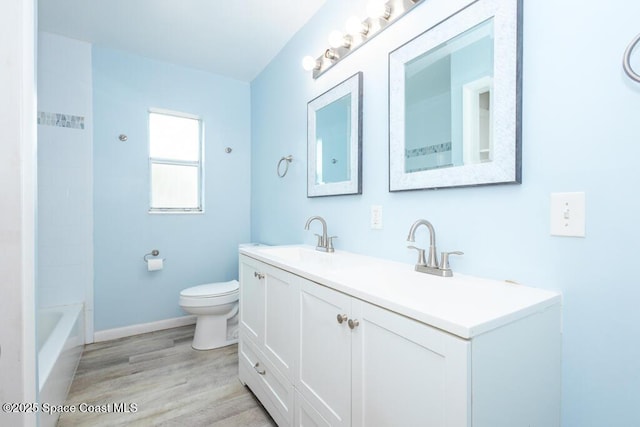 1108 Abington St, Cocoa, FL 32922 - bathroom featuring double vanity, toilet, wood finished floors, baseboards, and bathing tub / shower combination