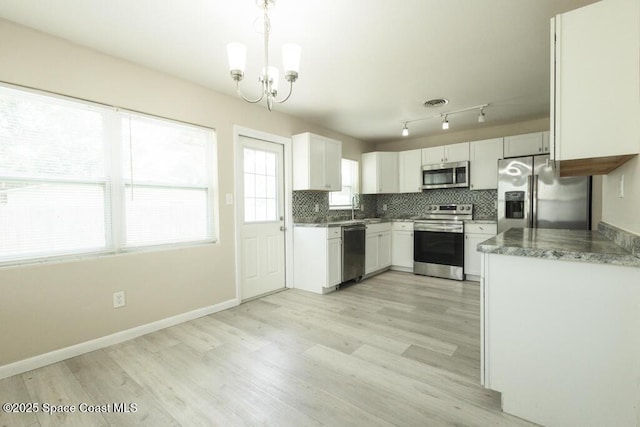 1108 Abington St, Cocoa, FL 32922 - kitchen with stainless steel appliances, a sink, a chandelier, light wood finished floors, and tasteful backsplash