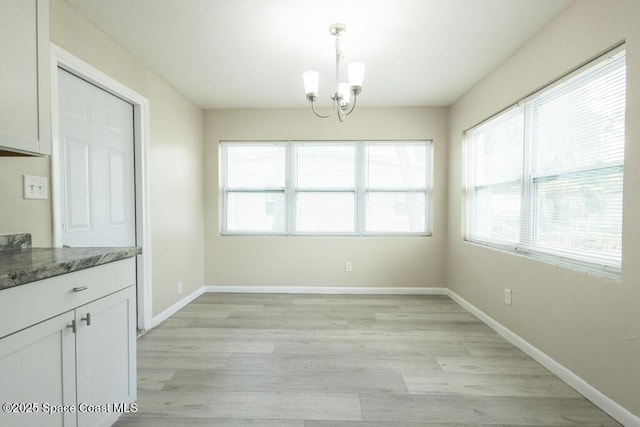 1108 Abington St, Cocoa, FL 32922 - unfurnished dining area featuring a chandelier, light wood-style floors, and baseboards