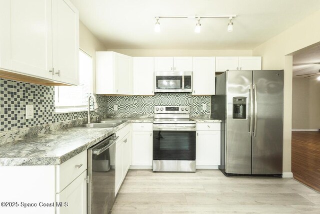 1108 Abington St, Cocoa, FL 32922 - kitchen featuring stainless steel appliances, a sink, white cabinets, and light wood finished floors
