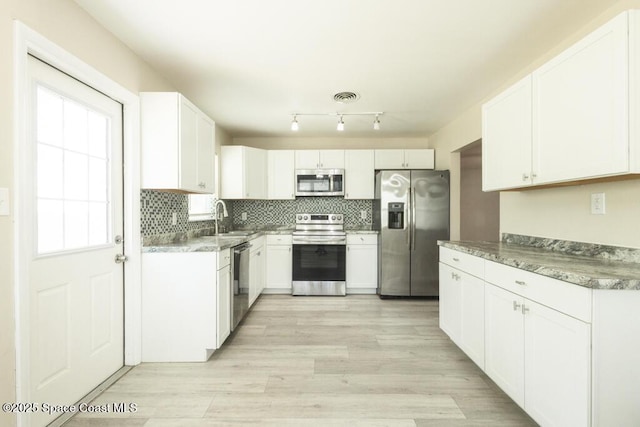 1108 Abington St, Cocoa, FL 32922 - kitchen featuring appliances with stainless steel finishes, a sink, tasteful backsplash, and white cabinetry