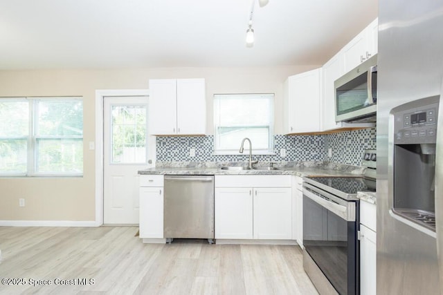 1108 Abington St, Cocoa, FL 32922 - kitchen featuring stainless steel appliances, a sink, light wood-style flooring, and tasteful backsplash