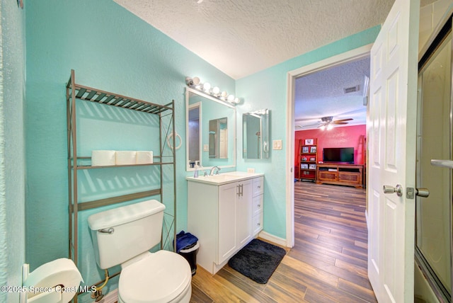 6485 Beard Ave, Cocoa, FL 32927 - bathroom featuring a textured ceiling, toilet, vanity, wood finished floors, and ceiling fan