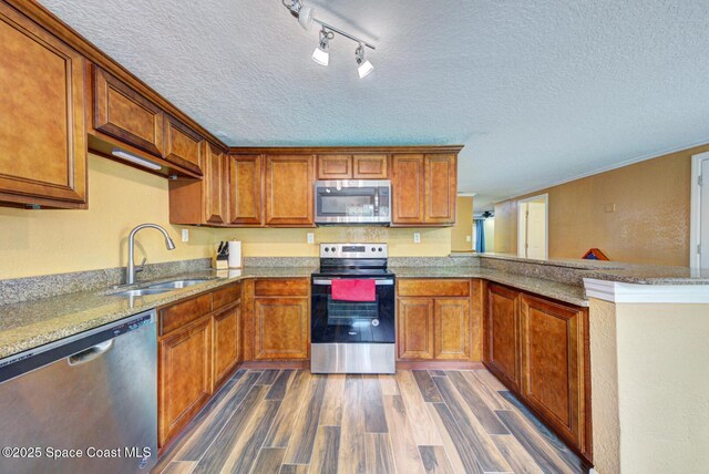 6485 Beard Ave, Cocoa, FL 32927 - kitchen with appliances with stainless steel finishes, a sink, a textured ceiling, dark wood-style flooring, and brown cabinetry