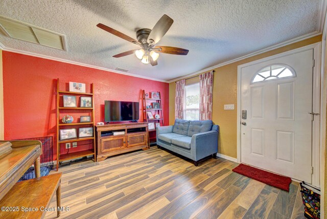 6485 Beard Ave, Cocoa, FL 32927 - living area with ornamental molding, wood finished floors, a textured ceiling, ceiling fan, and baseboards