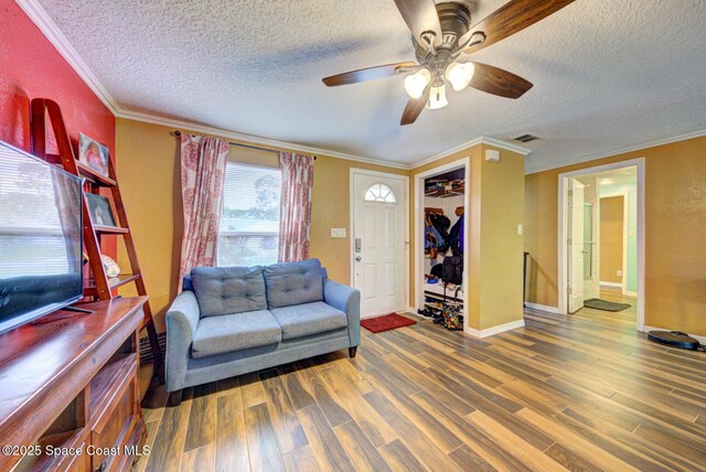 6485 Beard Ave, Cocoa, FL 32927 - living area featuring a textured ceiling, wood finished floors, crown molding, a ceiling fan, and baseboards