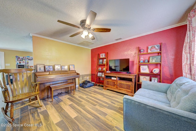 6485 Beard Ave, Cocoa, FL 32927 - living room featuring ceiling fan, wood finished floors, crown molding, and a textured ceiling