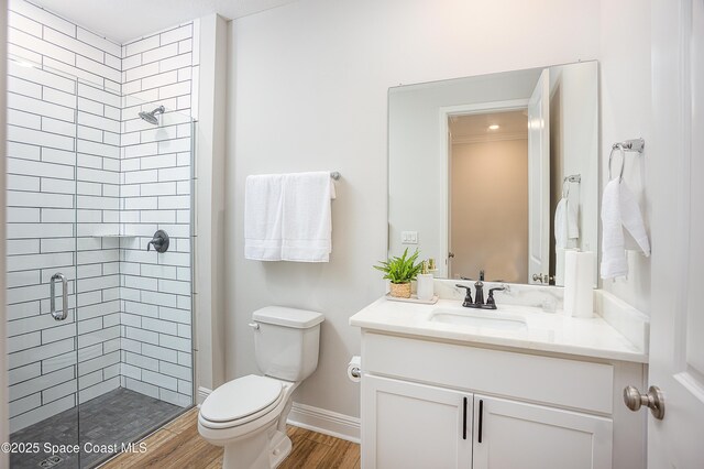 6305 Moonrise Dr, Merritt Island, FL 32953 - full bathroom featuring a shower stall, toilet, vanity, wood finished floors, and baseboards