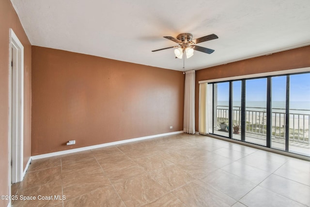 85 S Atlantic Ave Unit 403, Cocoa Beach, FL 32931 - empty room with a water view, a ceiling fan, baseboards, and tile patterned flooring