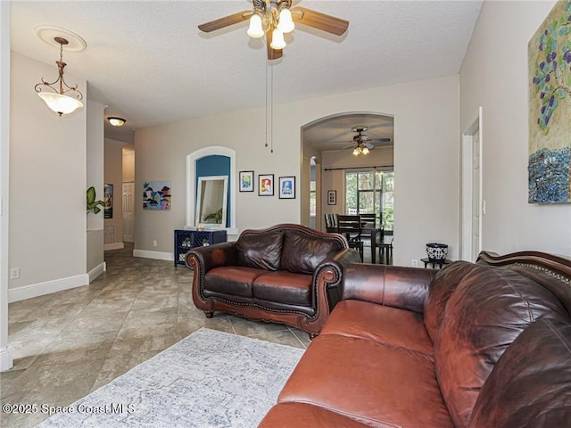 5151 4th Pl, Vero Beach, FL 32968 - living room with ceiling fan, arched walkways, baseboards, and a textured ceiling