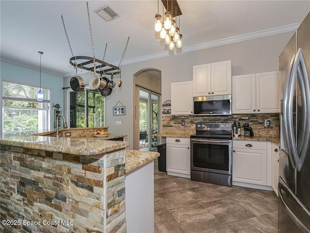 5151 4th Pl, Vero Beach, FL 32968 - kitchen featuring stainless steel appliances, arched walkways, tasteful backsplash, healthy amount of natural light, and ornamental molding