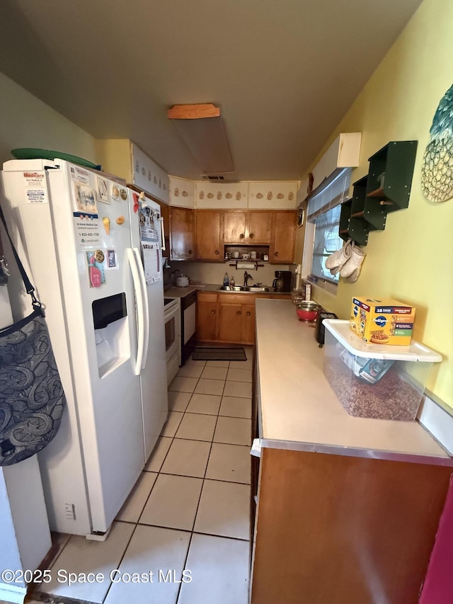 1003 Greenwood Way, Cocoa, FL 32922 - kitchen featuring white refrigerator with ice dispenser, a sink, light tile patterned flooring, light countertops, and stove