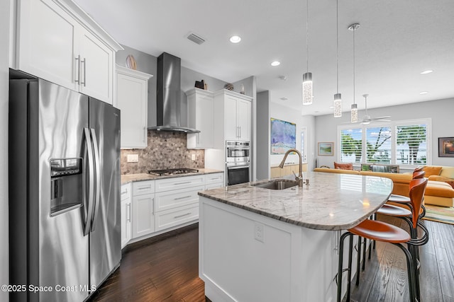 11 Pisces Ln, Rockledge, FL 32955 - kitchen with appliances with stainless steel finishes, wall chimney exhaust hood, dark wood-type flooring, open floor plan, and white cabinets