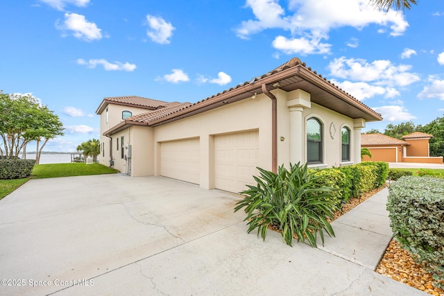 11 Pisces Ln, Rockledge, FL 32955 - view of front of property featuring a garage, concrete driveway, a tiled roof, and stucco siding