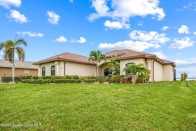 11 Pisces Ln, Rockledge, FL 32955 - mediterranean / spanish-style house with stucco siding, a tiled roof, and a front lawn