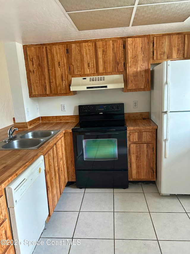 1704 University Ln Unit 703, Cocoa, FL 32922 - kitchen featuring white appliances, under cabinet range hood, a sink, and brown cabinetry