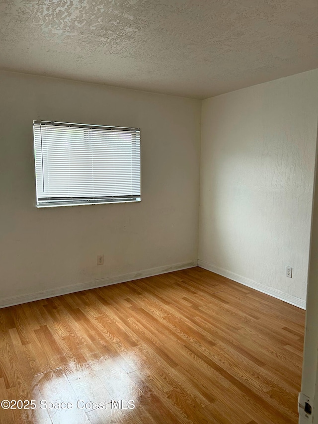 1704 University Ln Unit 703, Cocoa, FL 32922 - unfurnished room with light wood-style flooring, baseboards, and a textured ceiling