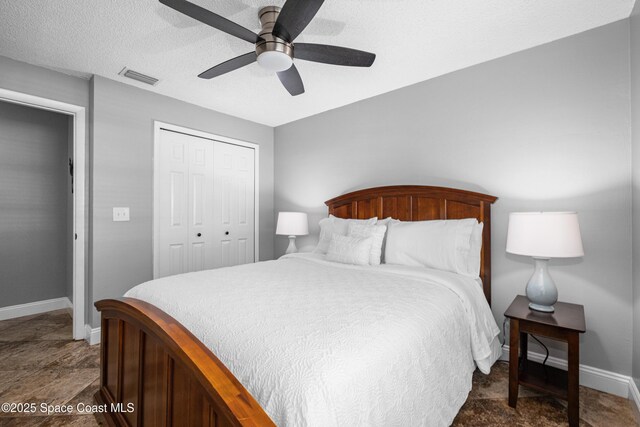816 Pine Shadows Ave W, Rockledge, FL 32955 - bedroom featuring a closet, a ceiling fan, a textured ceiling, and dark stone finish flooring