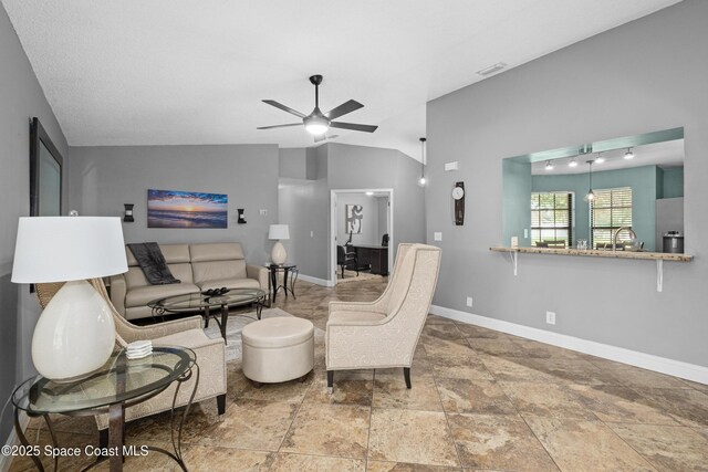 816 Pine Shadows Ave W, Rockledge, FL 32955 - living room featuring a ceiling fan, stone tile flooring, and vaulted ceiling