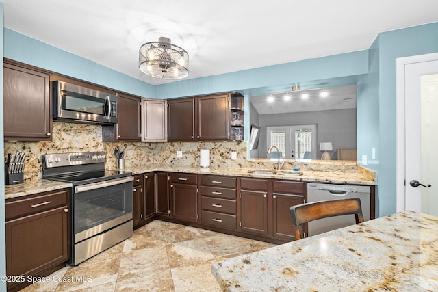 816 Pine Shadows Ave W, Rockledge, FL 32955 - kitchen with stainless steel appliances, tasteful backsplash, dark brown cabinetry, light stone countertops, and a chandelier