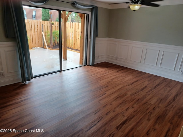 2416 Joshua Dr NE, Palm Bay, FL 32905 - empty room featuring wainscoting, a ceiling fan, dark wood-style floors, and a decorative wall