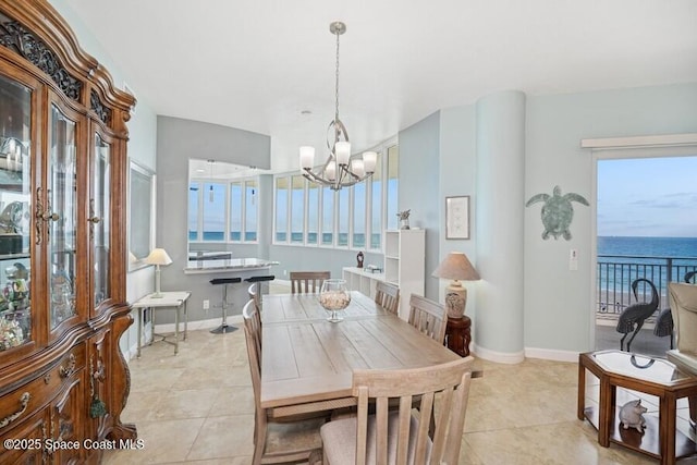 601 N Miramar Ave Unit 314, Indialantic, FL 32903 - dining area with a chandelier, light tile patterned floors, baseboards, and a water view