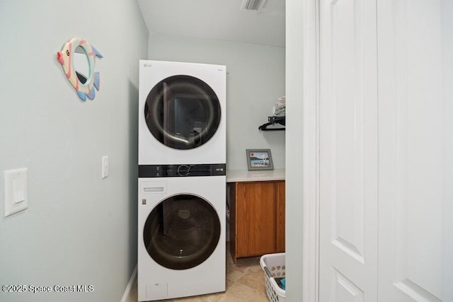 601 N Miramar Ave Unit 314, Indialantic, FL 32903 - laundry area with stacked washer and clothes dryer and light tile patterned floors