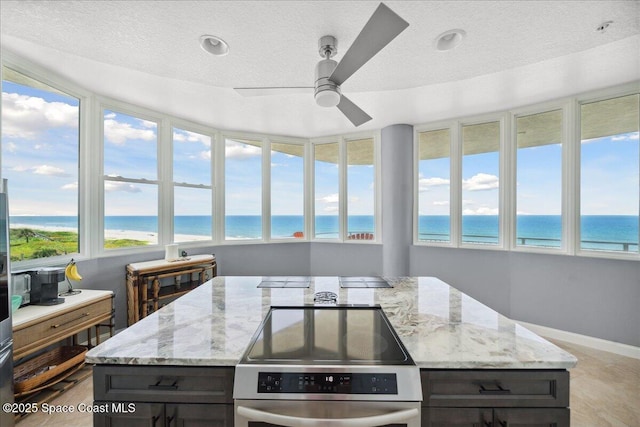 601 N Miramar Ave Unit 314, Indialantic, FL 32903 - sunroom featuring a water view, a textured ceiling, and baseboards